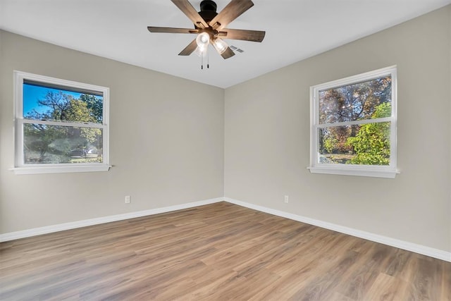 spare room with ceiling fan, plenty of natural light, and light hardwood / wood-style floors