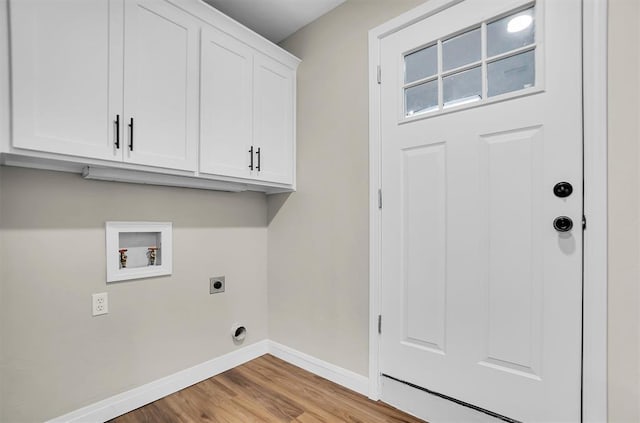 laundry area featuring hookup for an electric dryer, hookup for a washing machine, light wood-type flooring, and cabinets