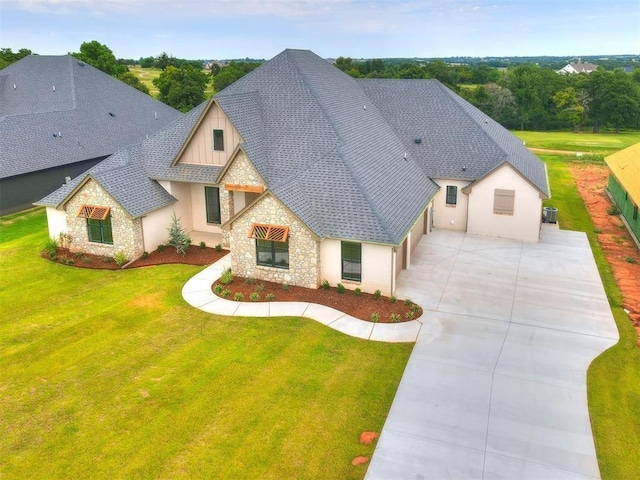 exterior space with a garage, a front yard, and central AC