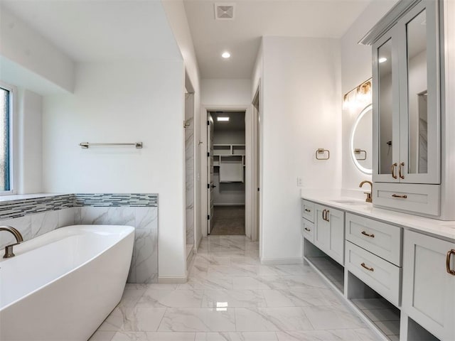 bathroom featuring vanity, tile walls, and a bathing tub