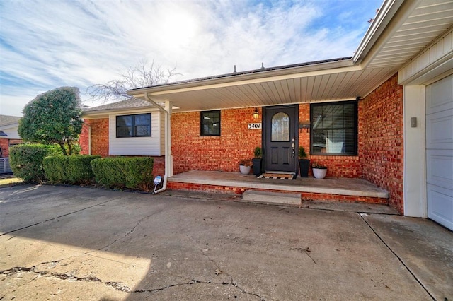 view of exterior entry featuring a garage and covered porch