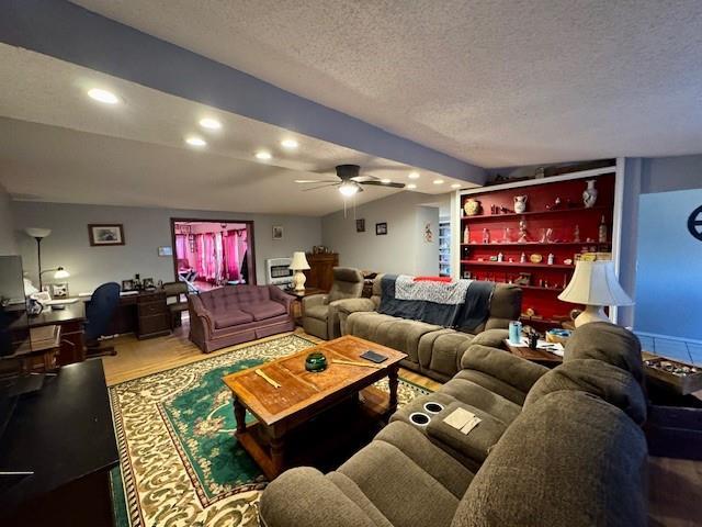 cinema with a textured ceiling, ceiling fan, hardwood / wood-style floors, and lofted ceiling