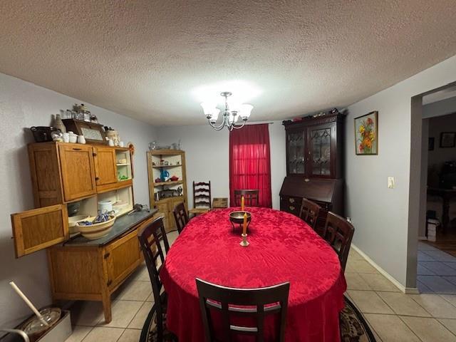 dining area with light tile patterned floors, a textured ceiling, and a notable chandelier