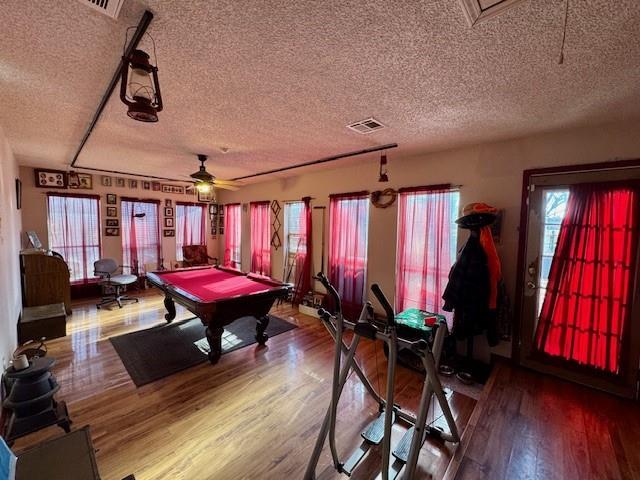 game room featuring wood-type flooring, a textured ceiling, ceiling fan, and billiards