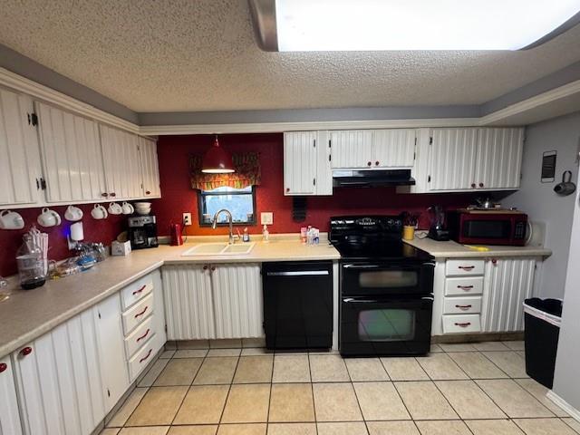 kitchen with sink, white cabinets, black appliances, and light tile patterned floors