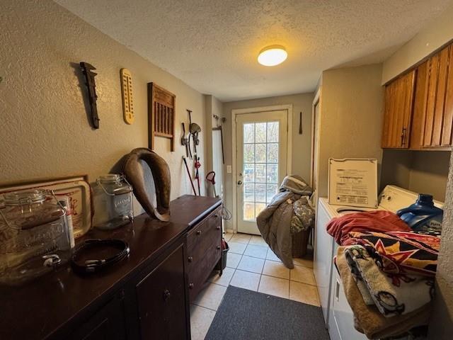 bedroom with access to outside, light tile patterned floors, and a textured ceiling