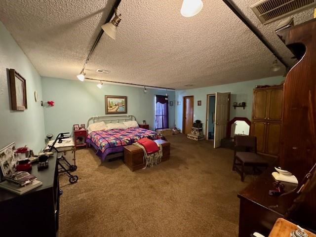 bedroom featuring a textured ceiling and carpet floors