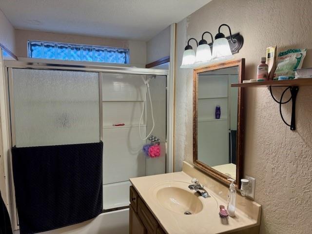 bathroom with vanity and bath / shower combo with glass door