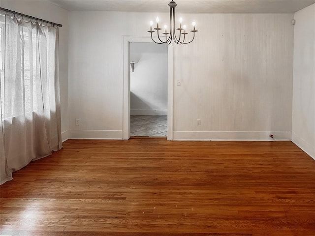 unfurnished dining area featuring hardwood / wood-style floors and an inviting chandelier