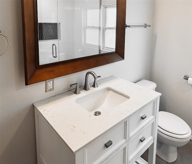 bathroom with vanity, toilet, and a shower with shower door