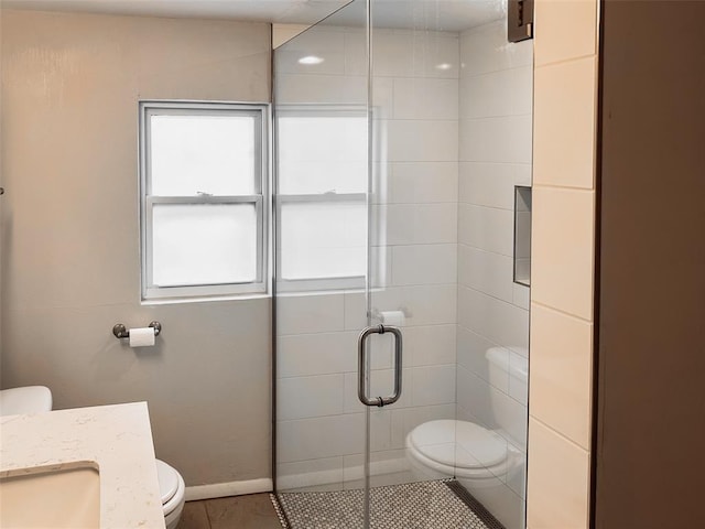 bathroom with tile patterned flooring, vanity, toilet, and an enclosed shower