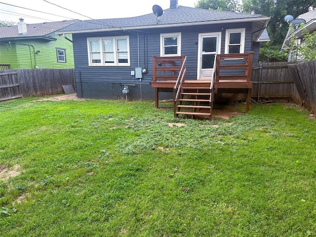 back of property featuring a deck and a lawn