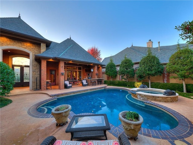 view of swimming pool featuring an outdoor bar, an in ground hot tub, and a patio