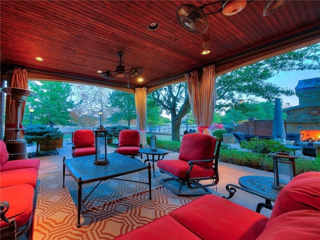 view of patio / terrace with an outdoor living space with a fireplace and ceiling fan