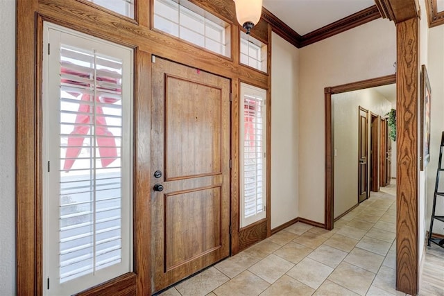 foyer entrance with light tile patterned floors and ornamental molding