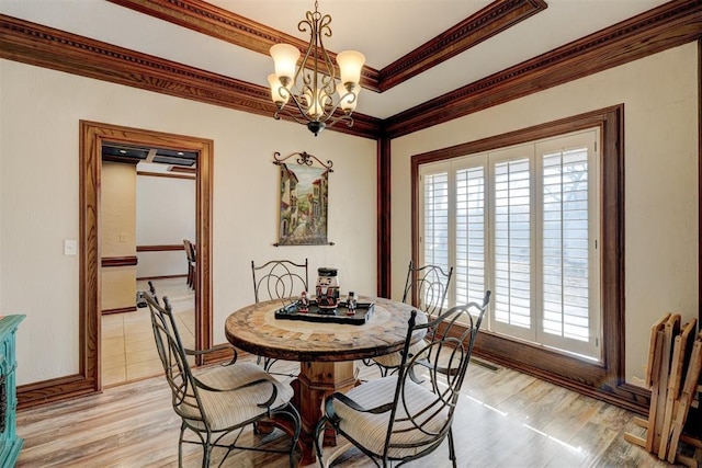 dining room with light hardwood / wood-style floors, an inviting chandelier, and ornamental molding