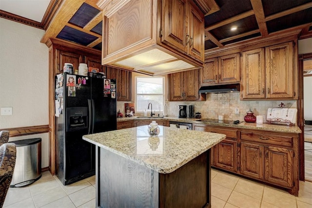 kitchen featuring light stone countertops, sink, coffered ceiling, a kitchen island, and black appliances