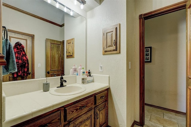 bathroom featuring tile patterned flooring, vanity, and ornamental molding