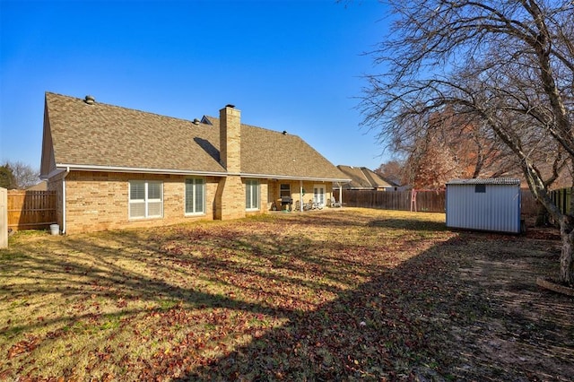 rear view of house with a storage shed and a lawn