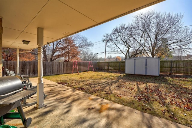 view of yard with a storage shed, a playground, and a patio