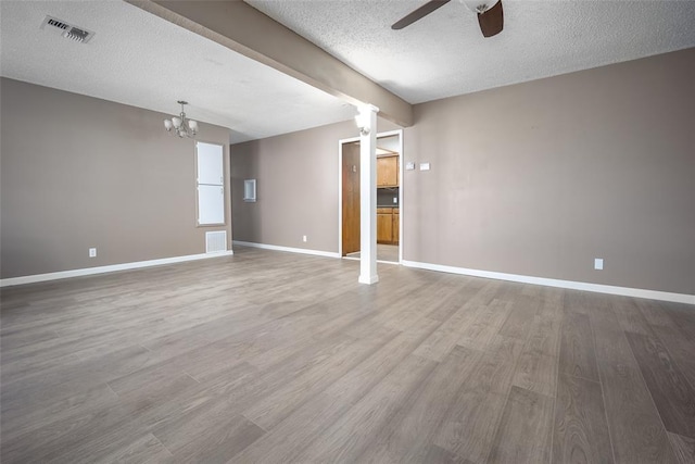 unfurnished room with hardwood / wood-style floors, ceiling fan with notable chandelier, and a textured ceiling