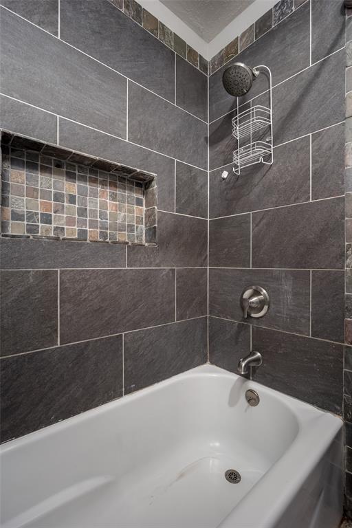 bathroom with tiled shower / bath combo