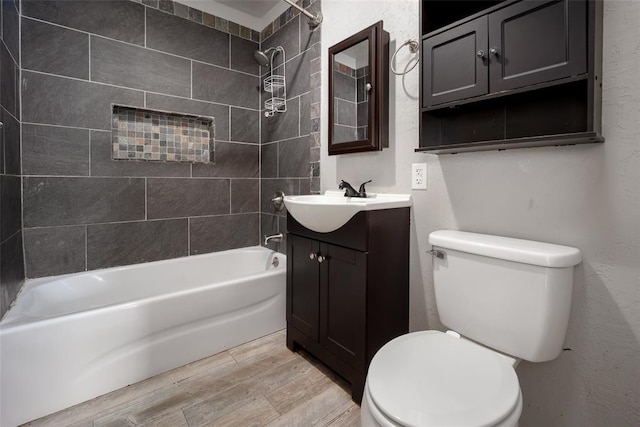 full bathroom featuring hardwood / wood-style flooring, vanity, toilet, and tiled shower / bath combo