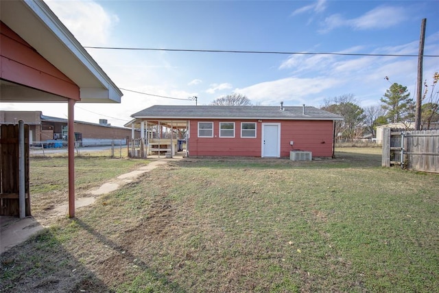 rear view of house with a lawn and central AC