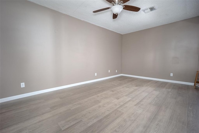 empty room with ceiling fan, a textured ceiling, and light hardwood / wood-style flooring