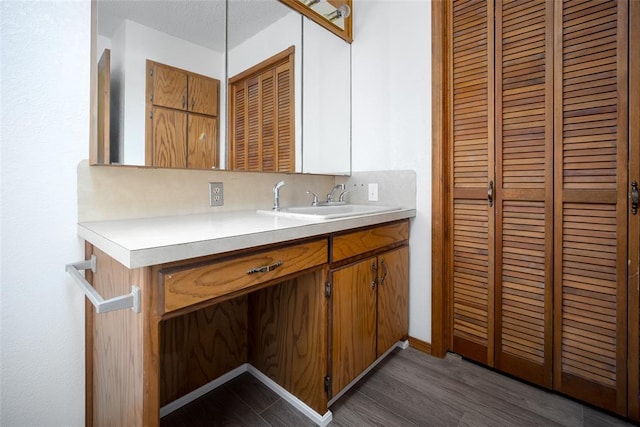 bathroom with a textured ceiling, vanity, hardwood / wood-style flooring, and backsplash