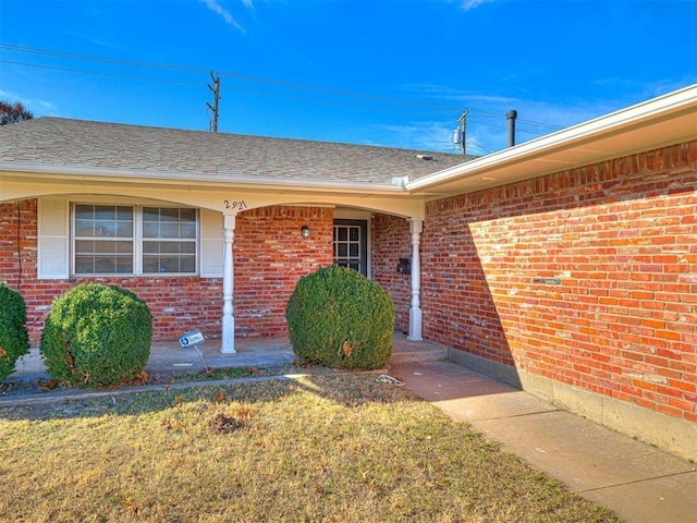 doorway to property featuring a lawn