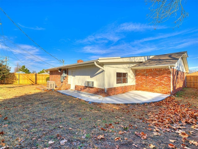 back of property with central air condition unit and a patio area