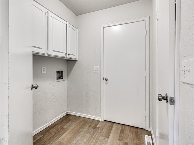 washroom featuring cabinets, washer hookup, and light hardwood / wood-style floors