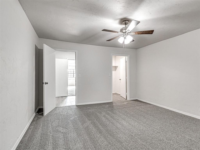 spare room featuring carpet, ceiling fan, and a textured ceiling