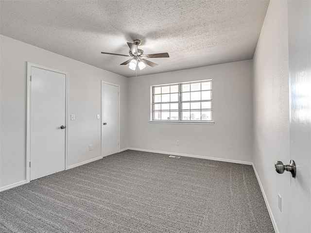 carpeted spare room with ceiling fan and a textured ceiling