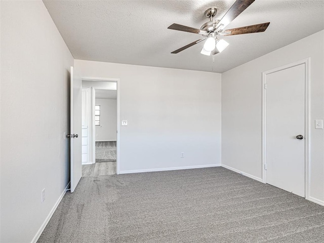 spare room featuring ceiling fan, carpet, and a textured ceiling