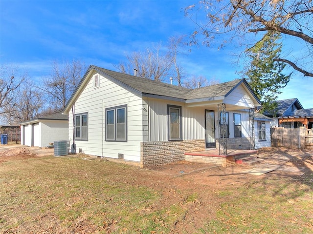 view of front of house with a garage, central air condition unit, and a front yard