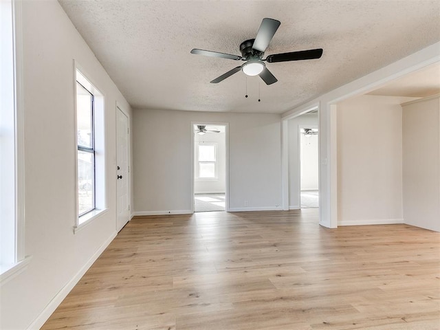 empty room featuring ceiling fan, a textured ceiling, and light wood-type flooring