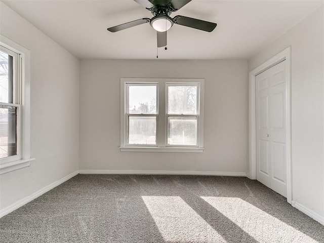 unfurnished bedroom with multiple windows, ceiling fan, a closet, and carpet