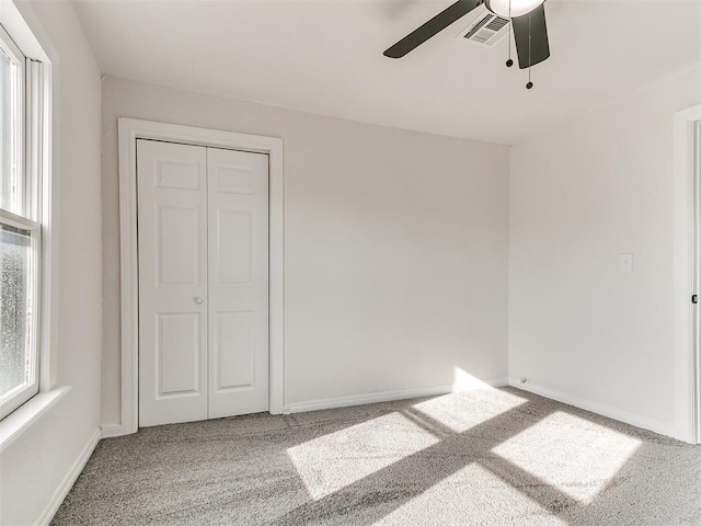 unfurnished bedroom featuring ceiling fan, a closet, and carpet