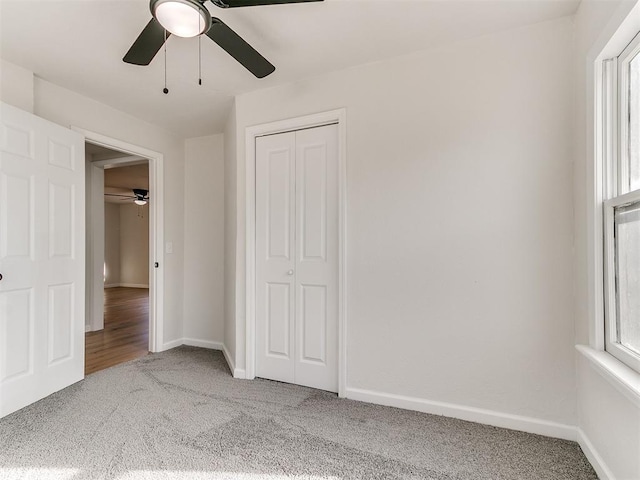 unfurnished bedroom with carpet flooring, ceiling fan, and a closet