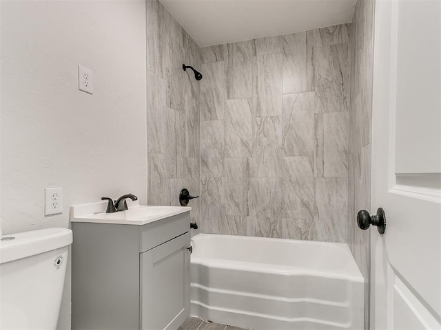 full bathroom featuring toilet, vanity, and tiled shower / bath combo