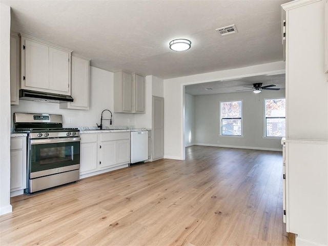 kitchen with ceiling fan, sink, light hardwood / wood-style flooring, stainless steel range oven, and white dishwasher