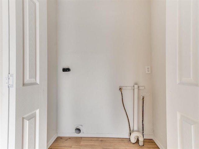 clothes washing area with hookup for an electric dryer, hookup for a washing machine, and light hardwood / wood-style floors