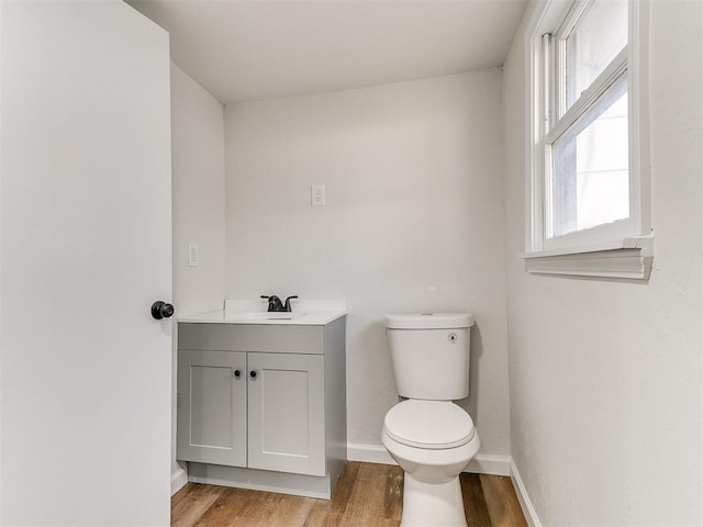 bathroom with hardwood / wood-style floors, vanity, and toilet