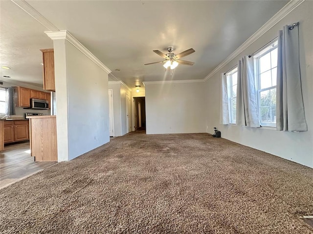 unfurnished living room with ceiling fan, light carpet, and ornamental molding