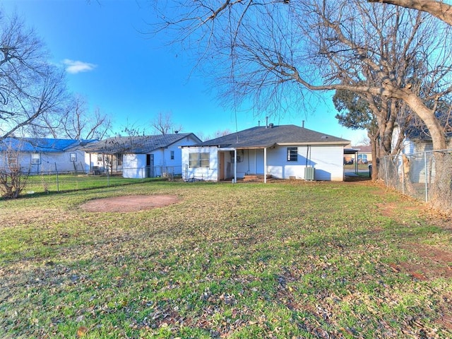 back of property with a yard and central AC unit