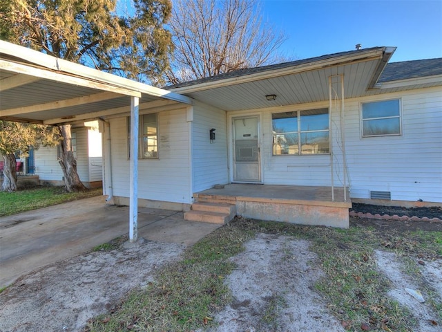 doorway to property featuring covered porch and a carport