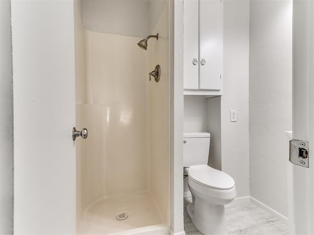 bathroom featuring walk in shower and toilet