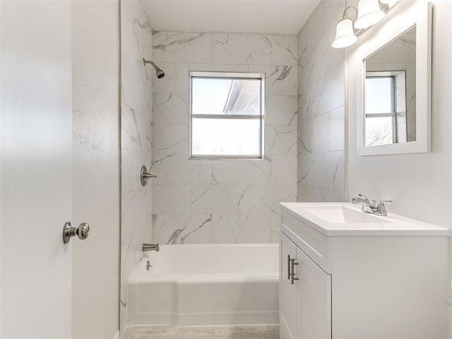 bathroom with vanity, tiled shower / bath combo, and a wealth of natural light